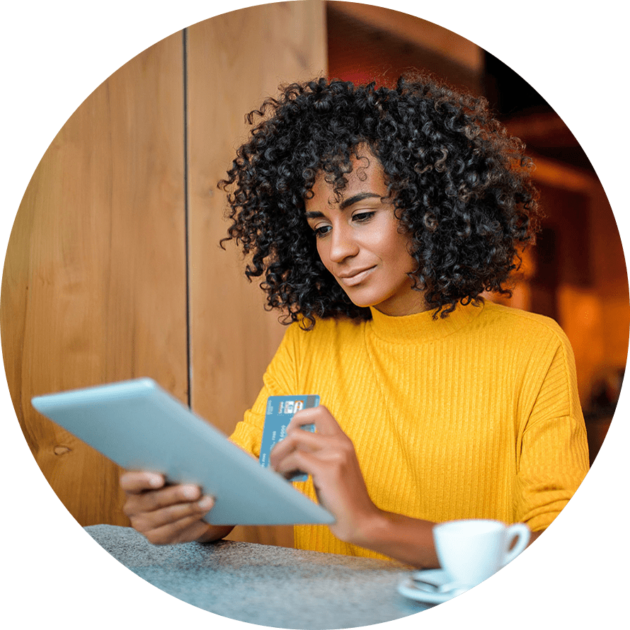 woman browsing tablet with card in hand